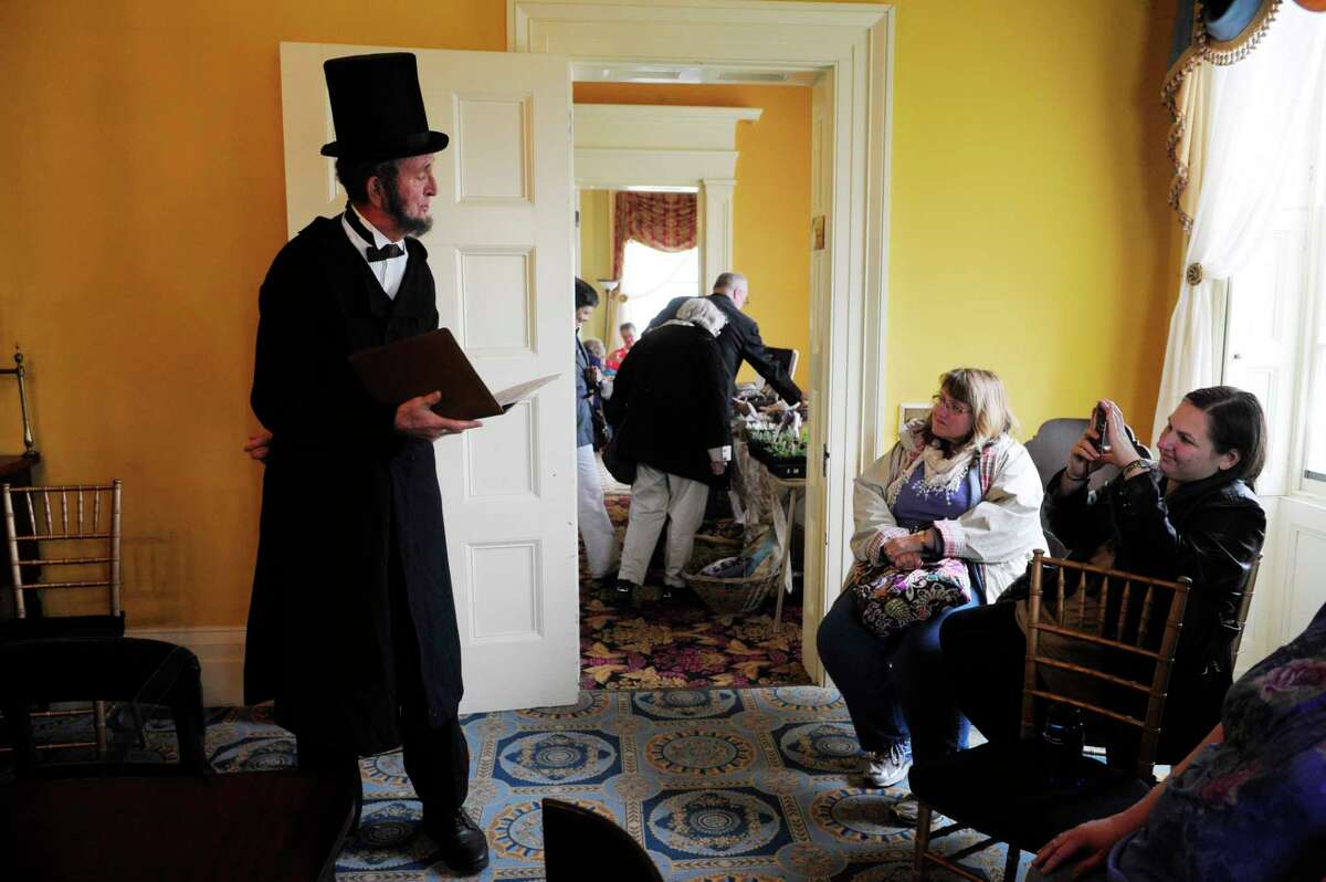 Civil War re-enactor John Baylis of Cassville, portrays President Lincoln as Stephanie Halpin, center, and her daughter Katy Halpin listen to Baylis read the Gettysburg Address at the Living History Day: Hidden Treasures of Albany event at Ten Broeck Mansion on Sunday, May 4, 2014, in Albany, N.Y. (Paul Buckowski / Times Union)