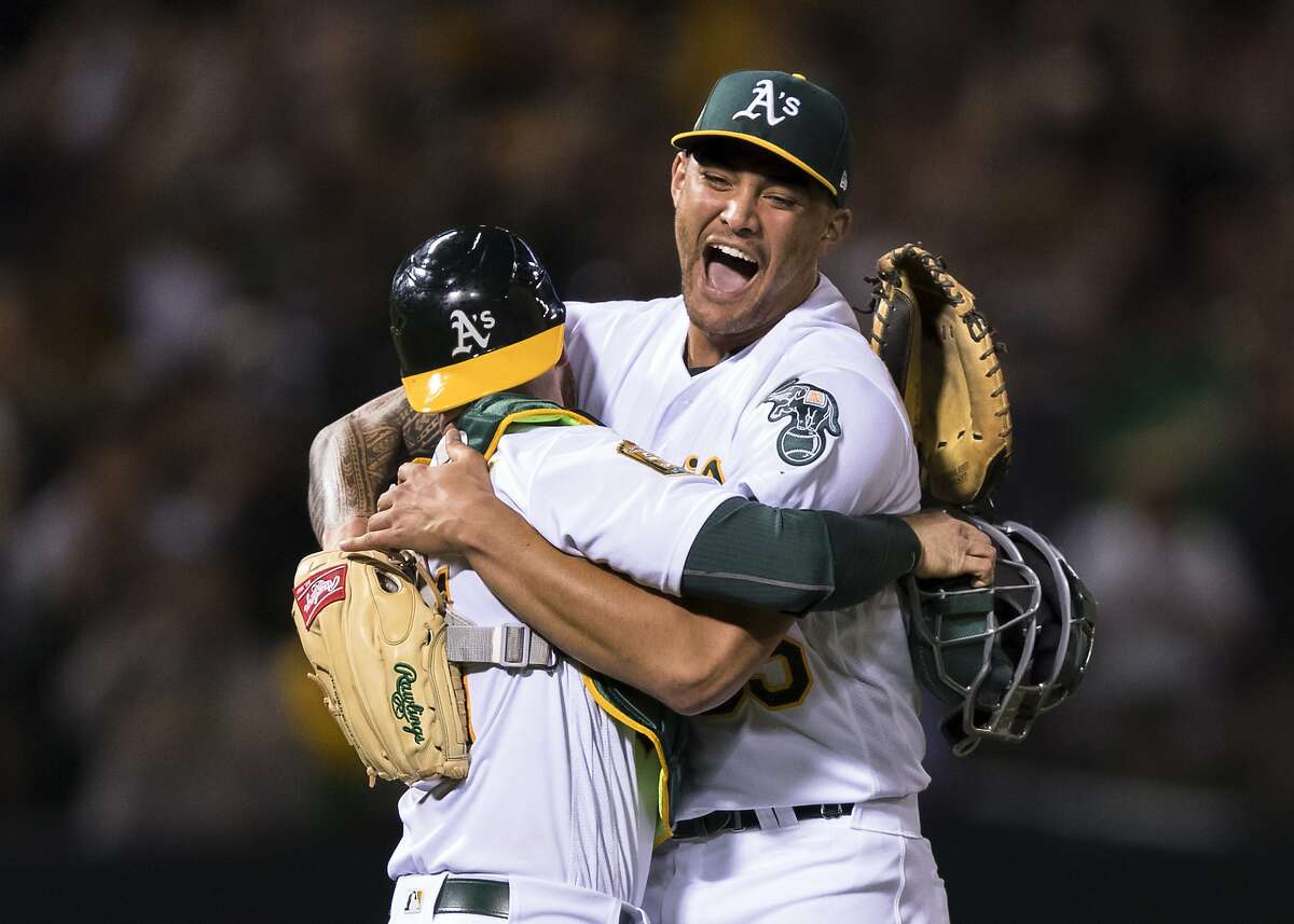 Oakland Athletics starting pitcher Sean Manaea, right, celebrates with catcher Jonathan Lucroy after pitching a no-hitter against the Boston Red Sox during a baseball game in Oakland, Calif., Saturday, April 21, 2018. The A's won 3-0. (AP Photo/John Hefti)
