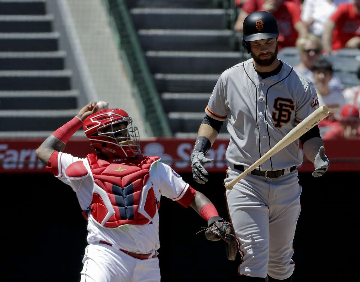San Francisco Giants' Brandon Belt, right, reacts after hitting a foul ball during the first inning of a baseball game against the Los Angeles Angels in Anaheim, Calif., Sunday, April 22, 2018.