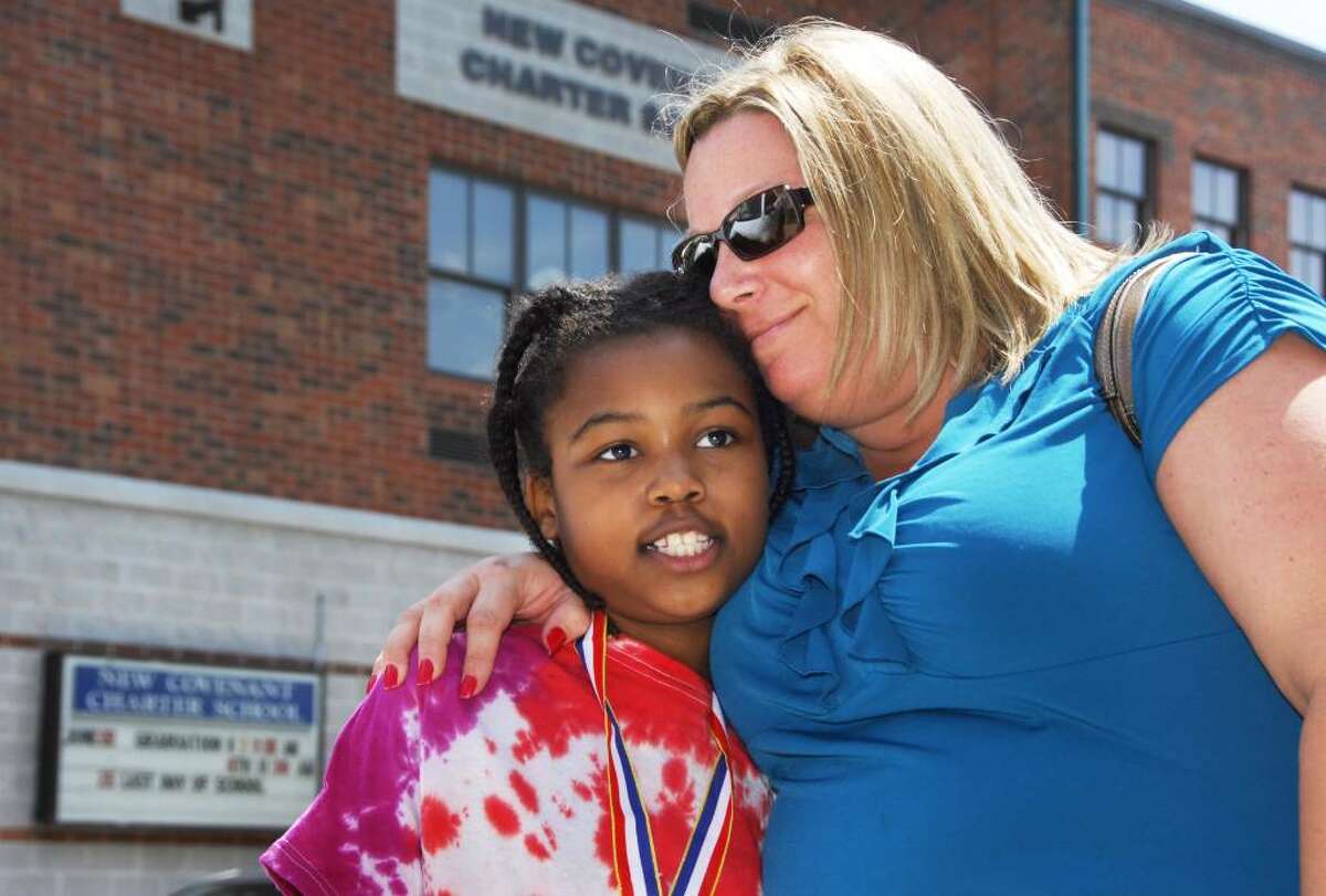 New Covenant Charter School literacy specialist Carolyn Kingsley with third grade student Diovionn Dukes outside the school on their final day Friday June 25, 2010. Kingsley says the mood inside the school today was "one of accomplishment and celebration". (John Carl D'Annibale / Times Union)