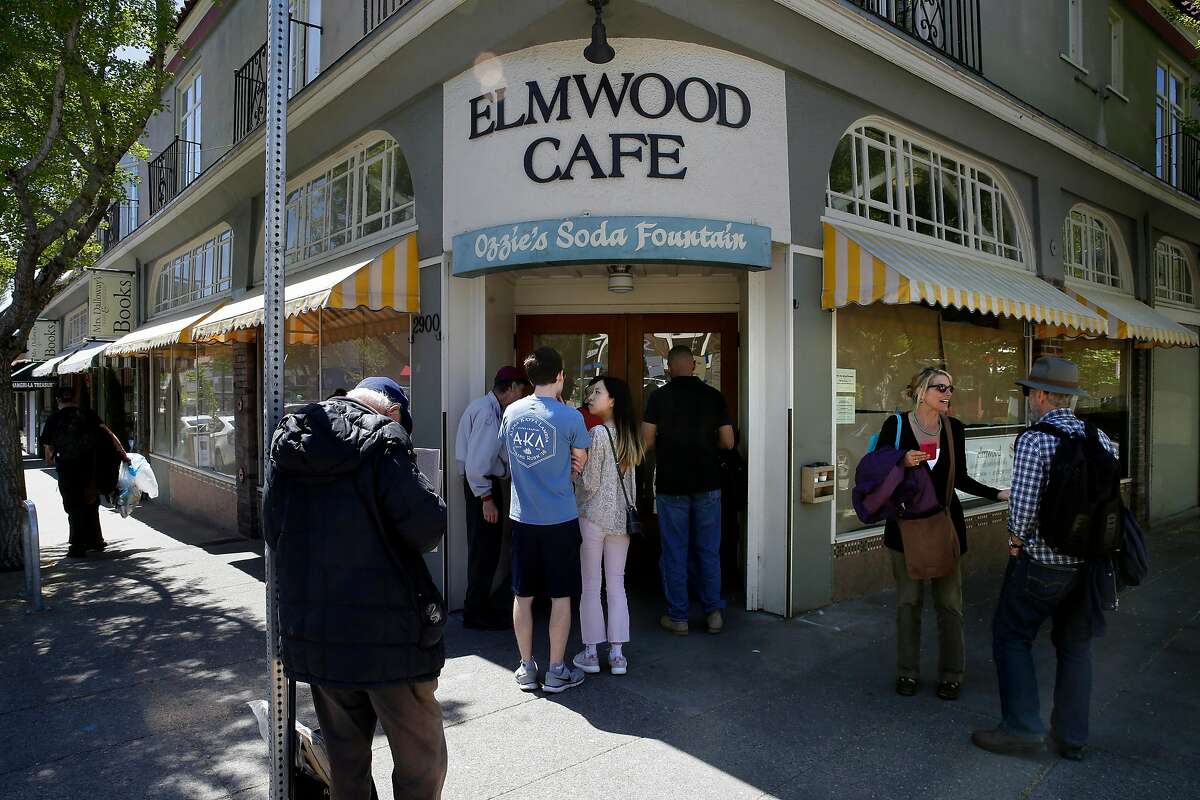 People gather at the front door of the Elmwood Cafe on College Ave. to read the sign about the sudden closure of the Cafe as seen on Fri. April 20, 2018, in Berkeley, Calif.