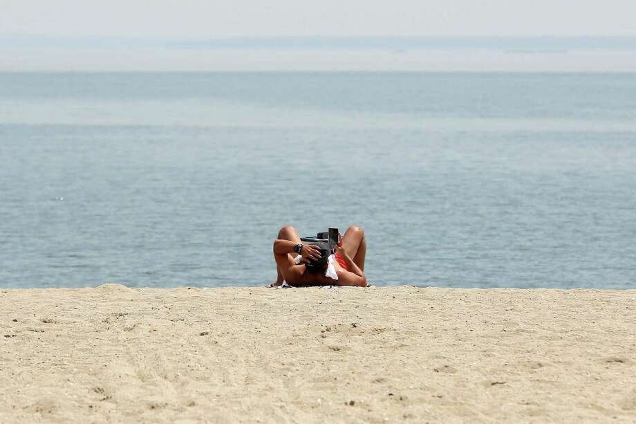New Dmv Fee Won T A Stamford Beach Sticker Stamfordadvocate File Photo A Man Scrolls Through His Phone While Lounging On The Sand At Cove