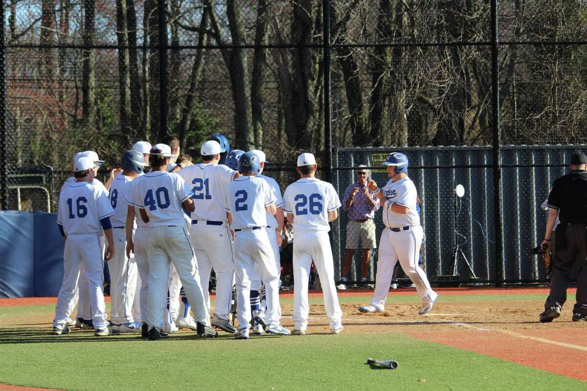 Darien's Sean O'Malley is greeted at home by his teammates after hitting a three-run home run in the sixth inning during an FCIAC baseball game between Darien and Stamford Monday afternoon at Darien High School in Darien, Conn. Darien defeated Stamford 6-2.