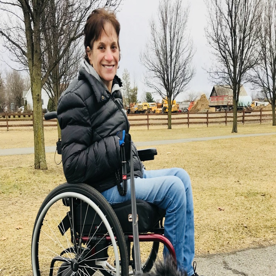 Nancy Ladd-Butz, who was severely injured and paralyzed by a falling boulder at Thacher Park last summer, is seen in her wheelchair at The Crossings in Colonie with her dog, Leo (Provided photo) Photo: Provided Photo
