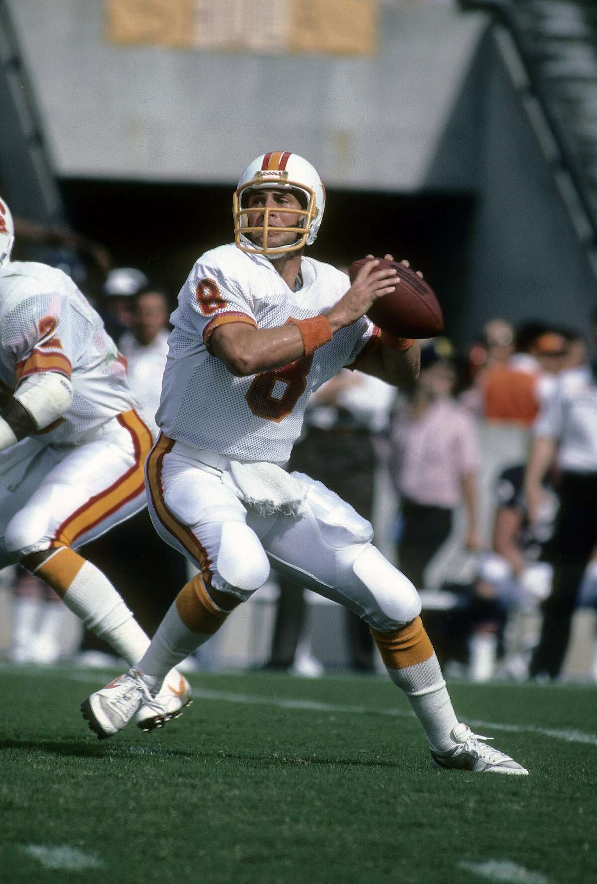 CHICAGO, IL - CIRCA 1980's: Quarterback Steve Young #8 of the Tampa Bay Buccaneers drops back to pass against the Chicago Bears during a mid circa 1980's NFL football game at Soldiers Field in Chicago, Illinois. Young played for the Buccaneers from 1985-