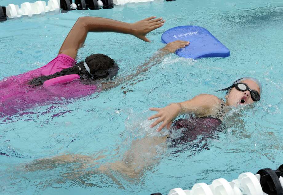 Searra Diggs, 11, of Danbury, left, and Arianna Petta, 7, of Brookfield, swim freestyle during the Western Connecticut YMCA Makos Swim Clinic, Tuesday, July 31, 2012. Photo: Carol Kaliff / Carol Kaliff / The News-Times