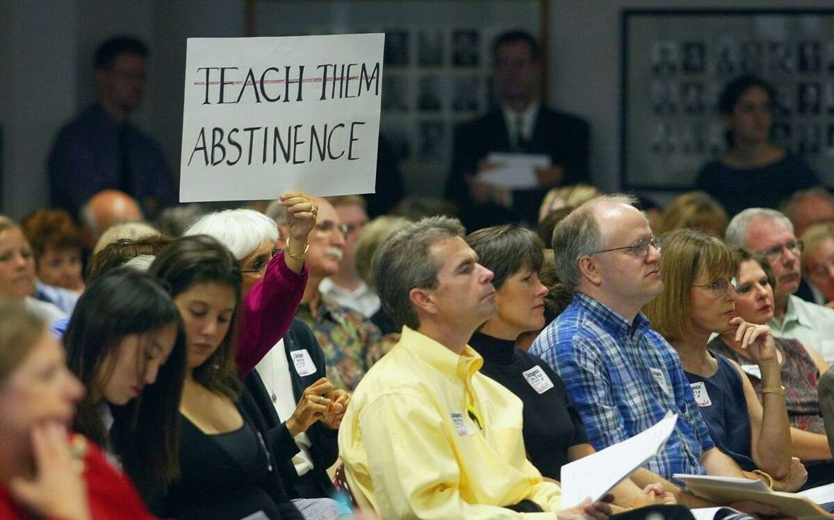 A woman holds a sign during a State Board of Education public hearing in 2004 in Austin on new health textbooks.