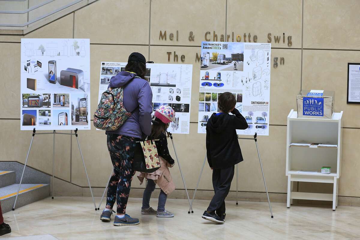 Anahi Palomares (l to r), Olive Franco, 5; and Judah Franco, 8, look over designs for replacement of San Francisco's on-street public toilets by three finalists at the main library in San Francisco, Calif., on Tuesday, April 24, 2018.