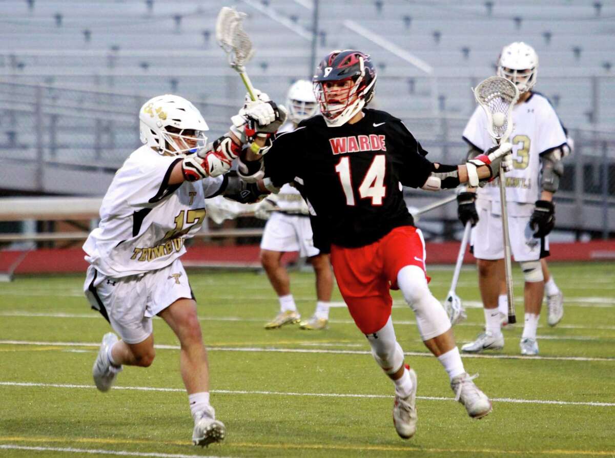 Fairfield Warde's Sam Palmer (14), right, drives towards the gaol as Trumbull's Jett Hughes (17) defends during boys lacrosse action in Trumbull, Conn., on Tuesday Apr. 24, 2018.