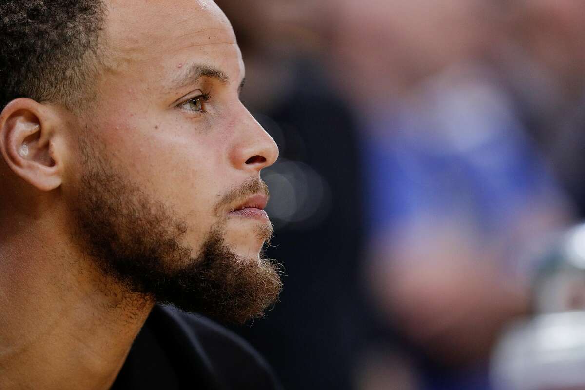 Golden State Warriors' Stephen Curry watches from the bench in the fourth quarter during game 5 of round 1 of the Western Conference Finals between the Golden State Warriors and the San Antonio Spurs at Oracle Arena on Tuesday, April 24, 2018 in Oakland, Calif.