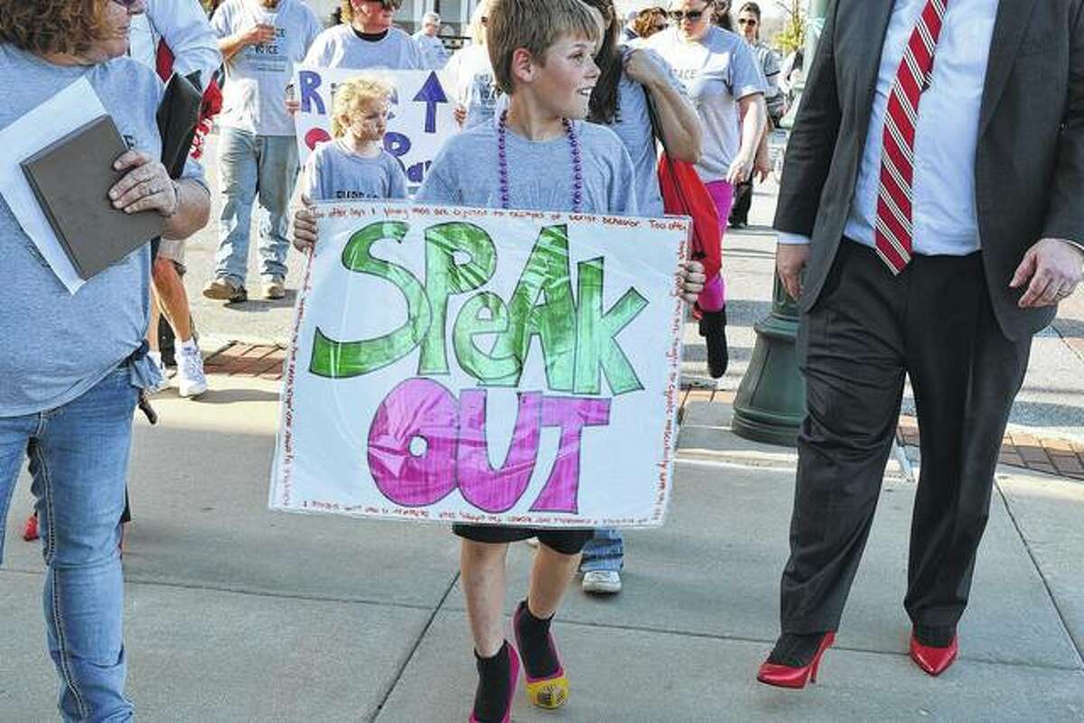 Seth Dober, 9, the son of Jessica Cowgur and Cassidy Dober of Jacksonville, walks Tuesday in the 11th annual Walk A Mile in Her Shoes event in downtown Jacksonville. The event helps raise awareness of sexual assault and benefits the Prairie Center Against Sexual Assault.