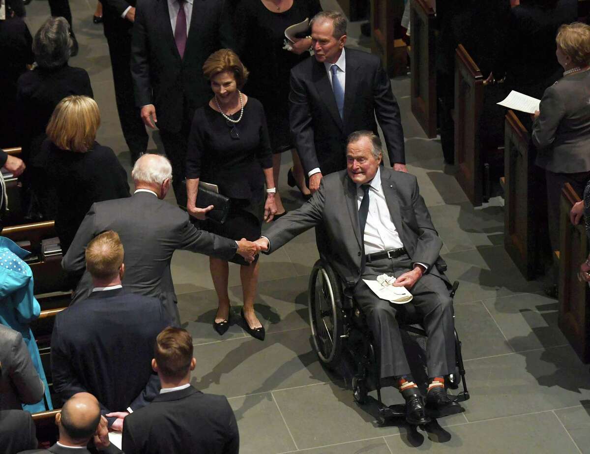 TOPSHOT - Former US President George H.W. Bush exits the funeral of his wife First Lady Barbara Bush, followed by his daughter-in-law former First Lady Laura Bush and former President George W. Bush at St. Martin's Episcopal Church in Houston, Texas, on April 21, 2018. Bush was hospitalized the following day for an infection that had spread to the bloodstream, but responded to treatment and was moved out of intensive care on April 25, 2018.