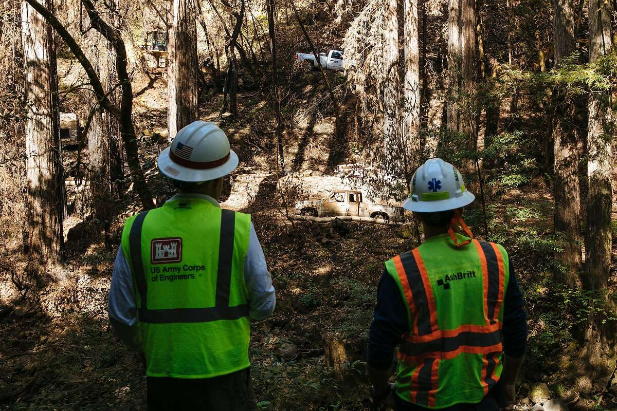 Edward Johnson of US Army Corps of Engineers and Brett Postelli, Safety Officer for AshBritt Environmental, watch crew work to clear out at a complex debris removal site in Santa Rosa, Calif., Monday, April 23, 2018.