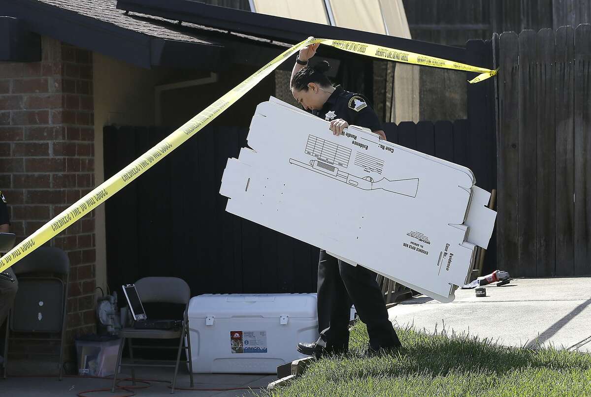 A Sacramento Sheriff's deputy carries evidence boxes into the home of murder suspect Joseph DeAngelo Thursday, April 26, 2018, in Citrus Heights, Calif. DeAngelo was taken into custody, Tuesday, on suspicion of committing multiple slayings and rapes in the 1970's and 1980's in California. (AP Photo/Rich Pedroncelli)