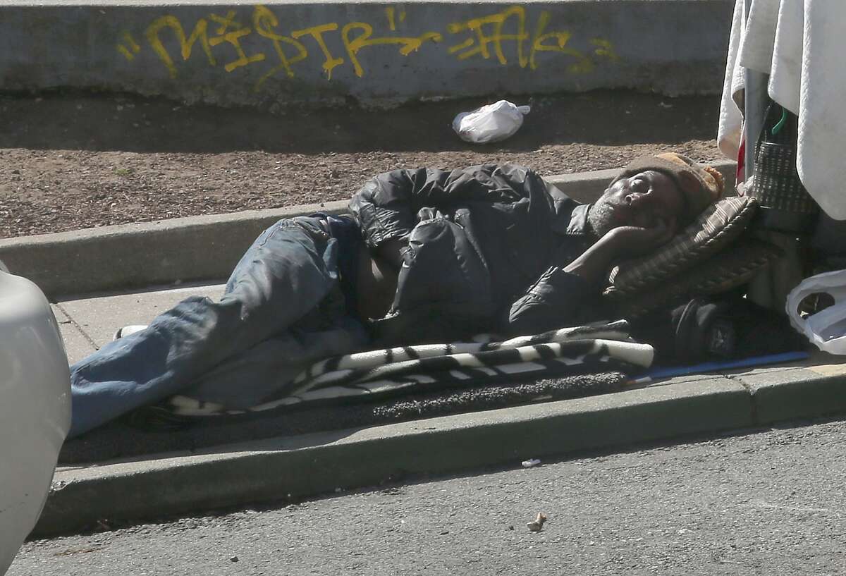 2018年4月20日星期五，在加州旧金山纳托马街上，一名男子睡觉。市政厅对困扰SOMA人行道的踏板车采取了果断行动，但对无家可归者、吸毒和粪便问题却几乎没有采取任何行动。