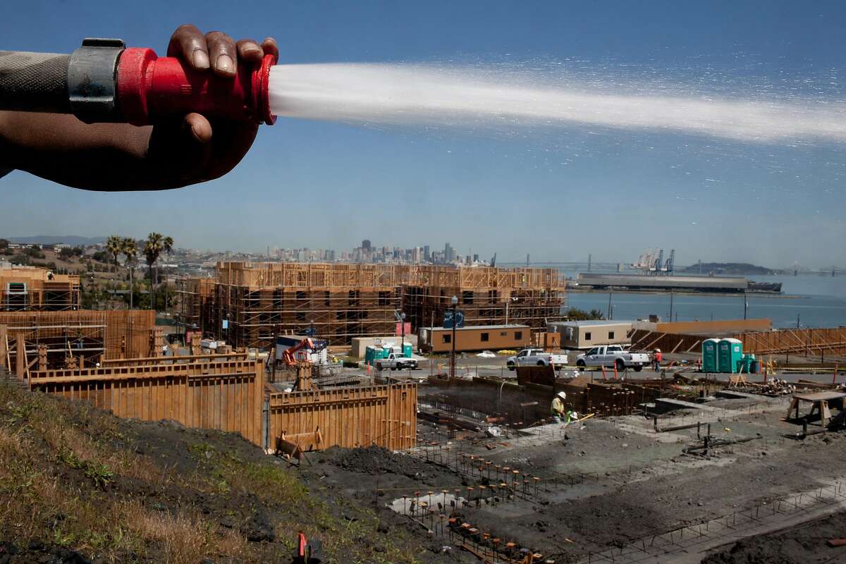 Michael Brown sprays down the land at the new development at the San Francisco Shipyard at Hunters Point in San Francisco, Calif. on Tuesday, May 13, 2014. These are the first homes hitting the market at the shipyard with 10,500 units.