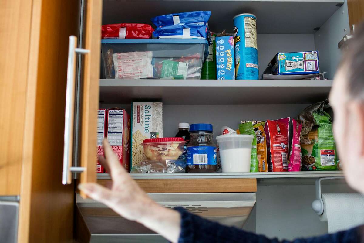 Cindy "Brandy" Werling opens a cabinet where she stores snacks for herself and treats for the cat in her apartment on Harrison Street in San Francisco.