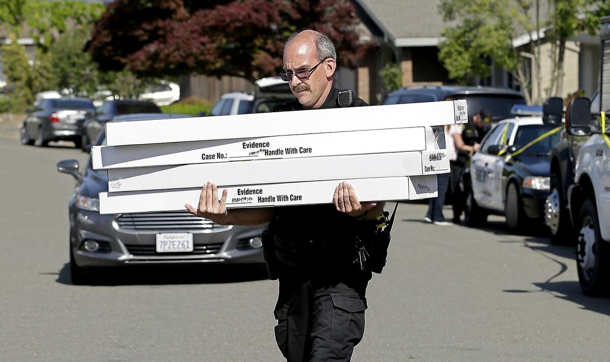 John Lopes, a crime scene investigator for the Sacramento County Sheriff's office, carries boxes of evidence taken from the home of murder suspect Joseph DeAngelo to a sheriff's vehicle Thursday, April 26, 2018, in Citrus Heights, Calif. DeAngelo, 72, was taken into custody Tuesday on suspicion of committing multiple homicides and rapes in the 1970s and 1980s in California. Authorities spent the day going through the home for evidence. (AP Photo/Rich Pedroncelli)