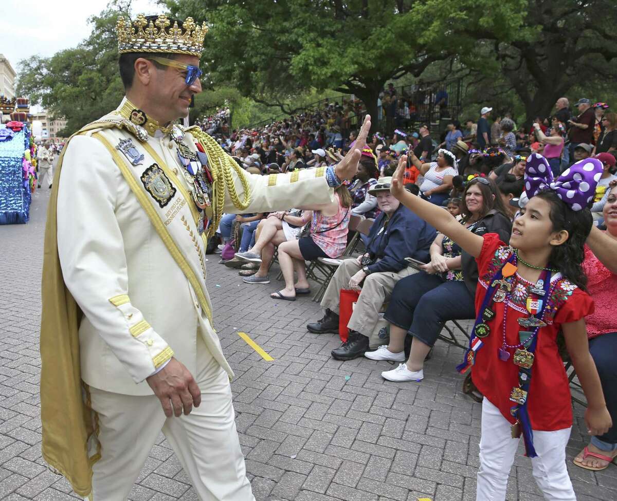 Rey Feo Ken Flores gets a high five during the Battle of Flowers Parade in Alamo Plaza last April. A major makeover of the plaza is headed for a City Council decision this week.