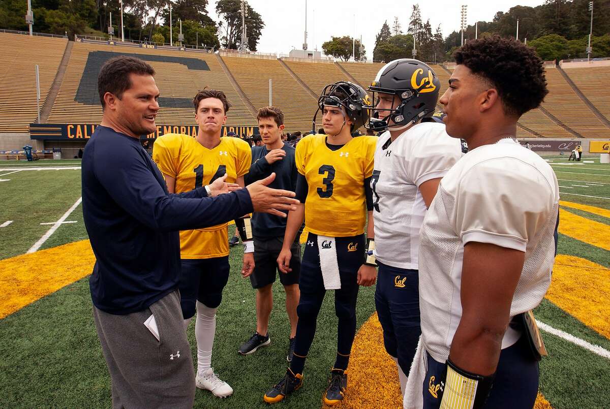 California quarterback coach Marques Tuiasosopo, left, talks to his QBs following the spring football scrimmage at Memorial Stadium, Saturday, April 28, 2018 in Berkeley, Calif. The quarterbacks are, from left, Chase Forrest (14), Ross Bowers (3), Chase Garber (7) and Brandon McIlwain. Man third from left is unidentified.