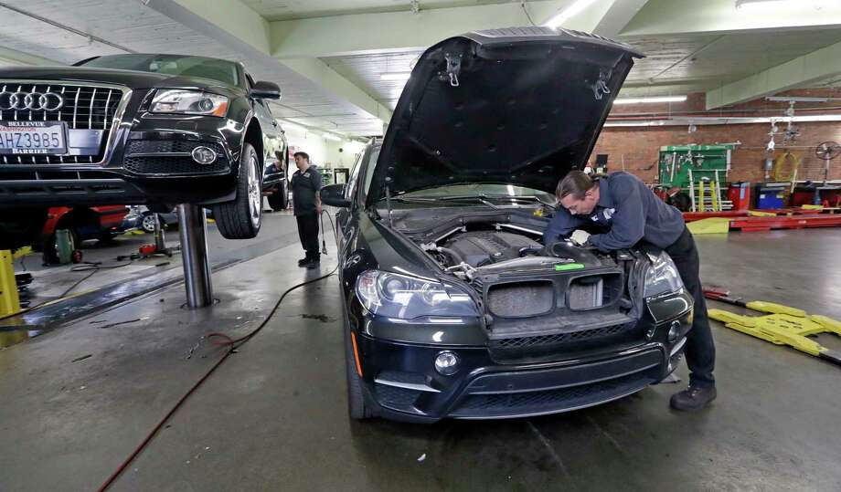 In this Wednesday, April 25, 2018, photo, auto technician Anthony Sterns, right, works to replace the coolant expansion tank on a 2011 BMW at the Fat City German Car service shop in Seattle. At first, dumping your old car might seem like a no-brainer, and you can't help picturing how good you would look in that new car. But automotive experts say you'll almost always come out ahead, at least financially, by fixing old faithful. (AP Photo/Elaine Thompson) Photo: Elaine Thompson / Copyright 2018 The Associated Press. All rights reserved.