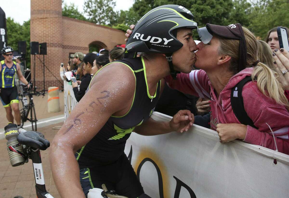 Rick Rivera kisses his wife while on his way to start the biking part of the 2018 Memorial Hermann IRONMAN® North American Championship Texas Triathlon on Saturday, April 28, 2018, in The Woodlands. The IRONMAN features 2.4 miles of swimming, 112 miles of biking and 26.2 miles of running. ( Yi-Chin Lee / Houston Chronicle )