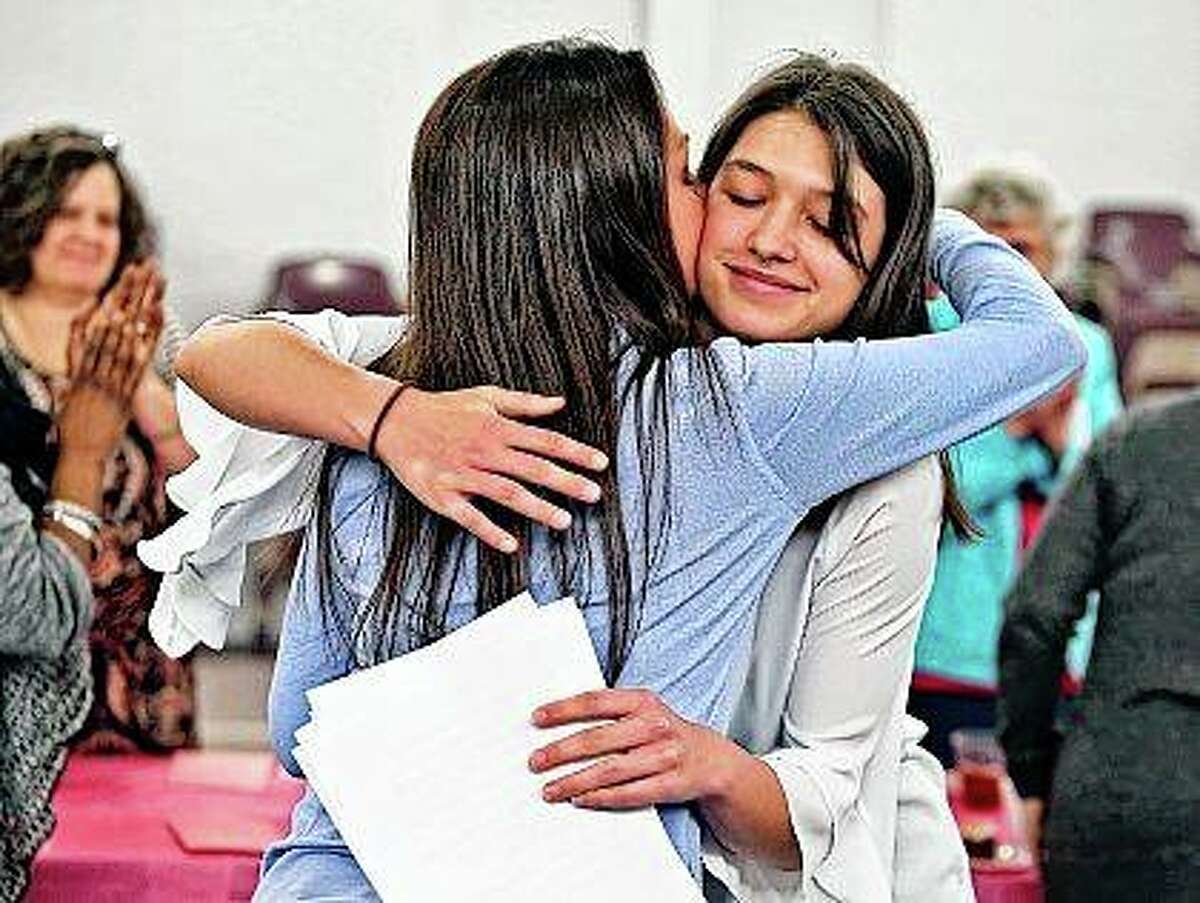 Olivia Weeks (right) gets a hug from her mother, Tabitha Weeks, after she read her essay that she wrote to get accepted into Harvard University during the Decatur Correctional Center Volunteer Luncheon and Program in Decatur. Before her mother went to prison in 2012 for an aggravated DUI that caused a death, Olivia was a competent student but not an outstanding one, certainly not one on track for an Ivy League education. When her mother left, Olivia, then 12 years old, made a choice to excel.