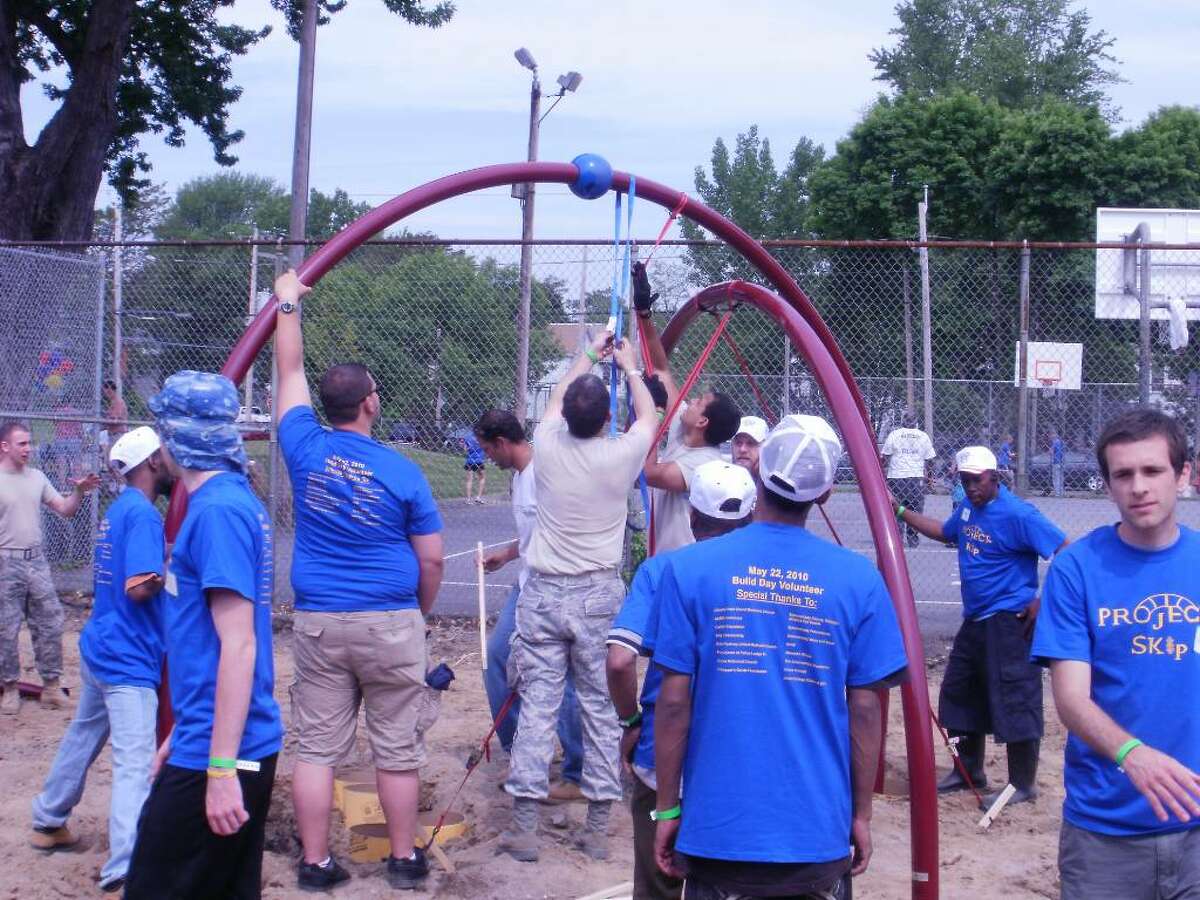 A crowd of volunteers helps create a new playground at Schenectady?s Jerry Burrell Park on May 22. A ribbon-cutting on Tuesday marked the official opening of the playground.