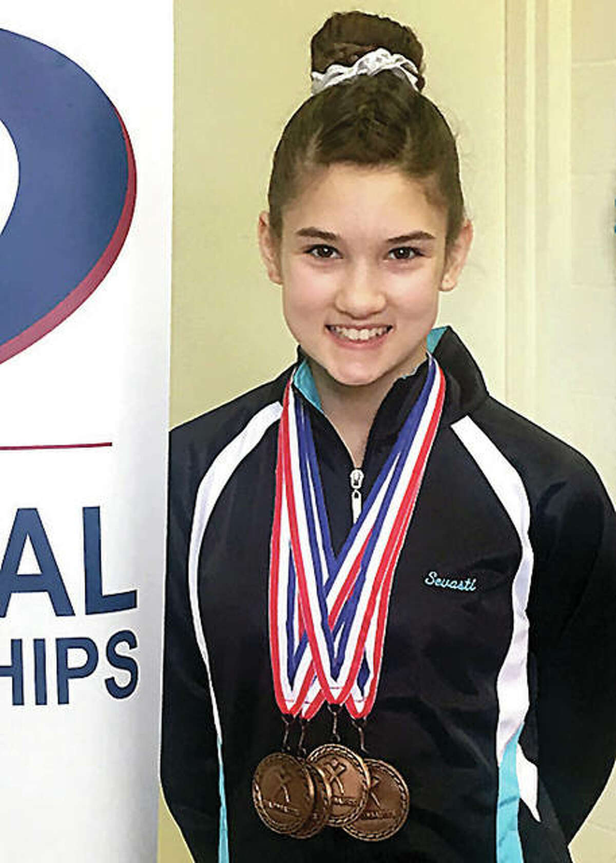 Sevasti Binolis, 13, of Mid Illinois Gymmastics in Godfrey, displays the medals she won at the recent Region 5 Gymnastics Championships in Ohio.