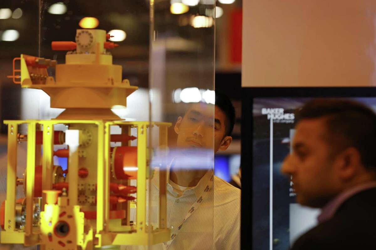 An attendee looks at a subsea light weight compact tree model at the Baker Hughes, a General Electric (GE) Company, booth during the 2018 Offshore Technology Conference (OTC) in Houston, Texas, U.S., on Monday, April 30, 2018. The OTC gathers energy professionals to exchange ideas and opinions to advance scientific and technical knowledge for offshore resources. Photographer: Aaron M. Sprecher/Bloomberg