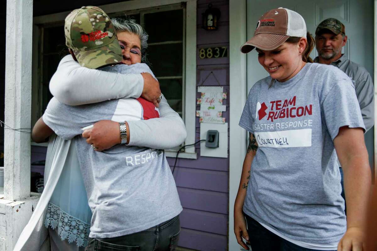 Estela Beaudreault, second from left, cries as she hugs Team Rubicon construction site supervisor Teaira Johnson before she sees her home, which was flooded during Hurricane Harvey and rebuilt by members of Team Rubicon, for the first time Monday, April 30, 2018 in Houston. Beaudreault's home is the first of 100 homes that Team Rubicon is rebuilding in the Houston area.