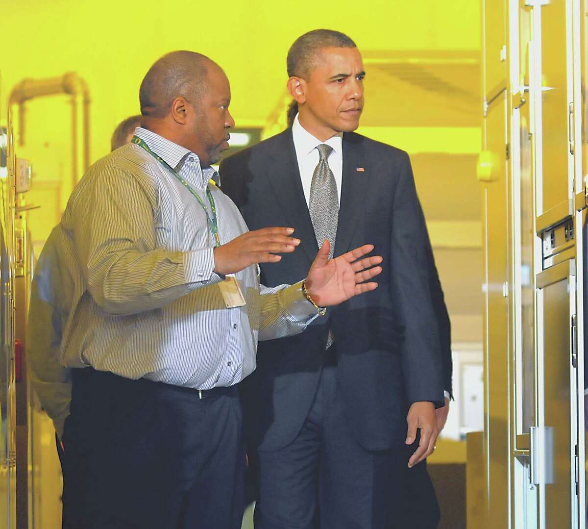 Warren Montgomery, left, CNSE assistant vice president of advanced technology and business development talks with President Barack Obama, right, as he tours a clean room on Tuesday, May 8, 2012, at University at Albany College of Nanoscale Science and Engineering in Albany, N.Y. (Cindy Schultz / Times Union)