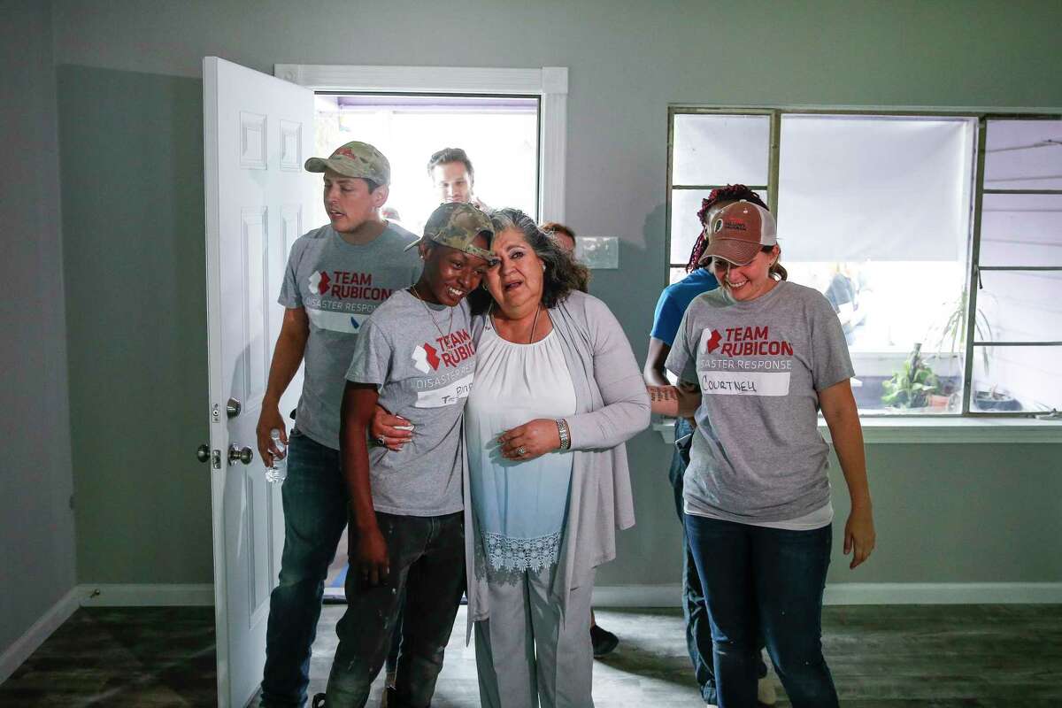 Estela Beaudreault, second from right, hugs Team Rubicon construction site supervisor Teaira Johnson, second from left, as she sees her home, which was flooded during Hurricane Harvey and rebuilt by members of Team Rubicon, for the first time Monday, April 30, 2018 in Houston. Beaudreault's home is the first of 100 homes that Team Rubicon is rebuilding in the Houston area.
