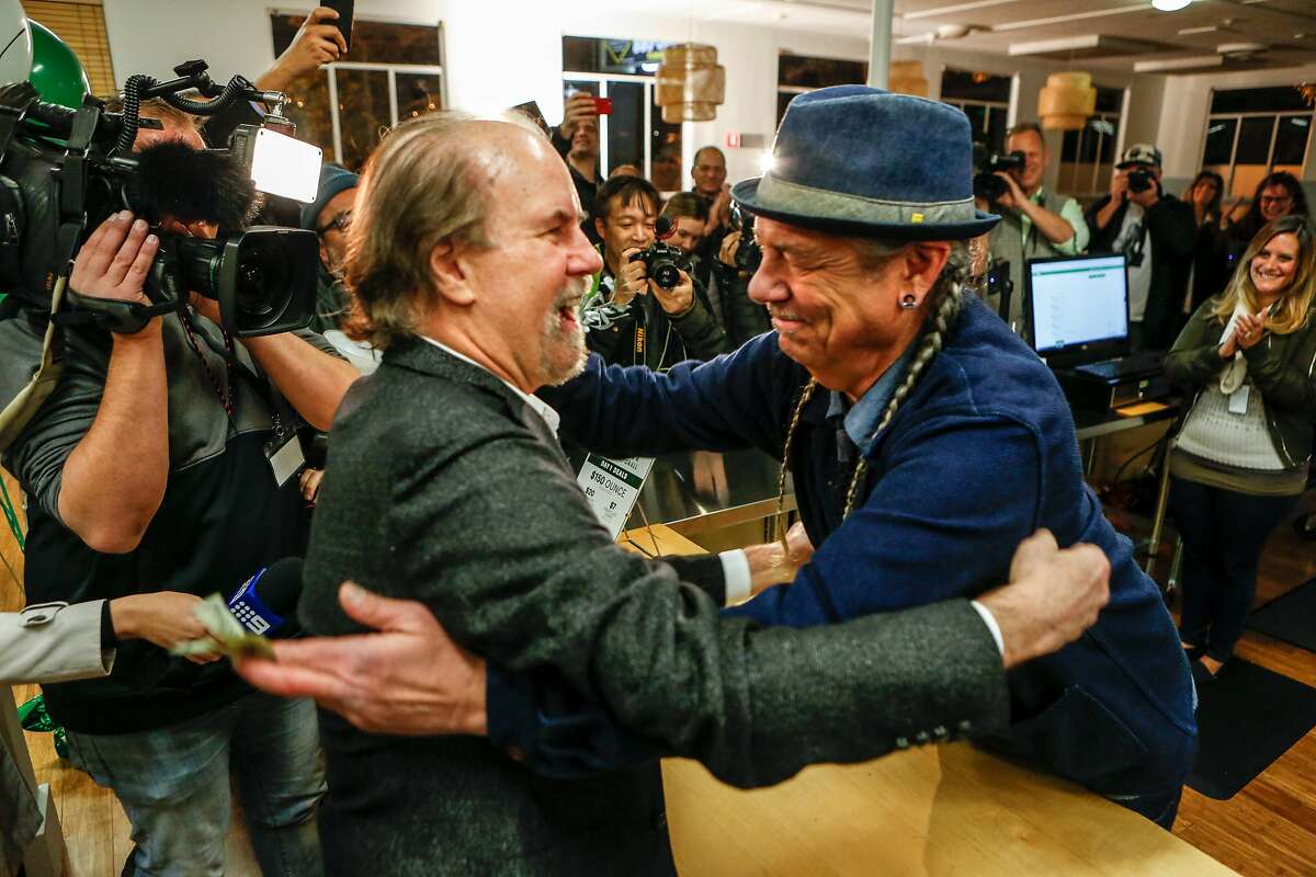 CEO of Harborside Health Center, Steve DeAngelo (right), makes the first sale at 6am to Henry Wyckowski on the first day of recreational marijuana sales in California on Monday, January 1, 2018 in Oakland, California.