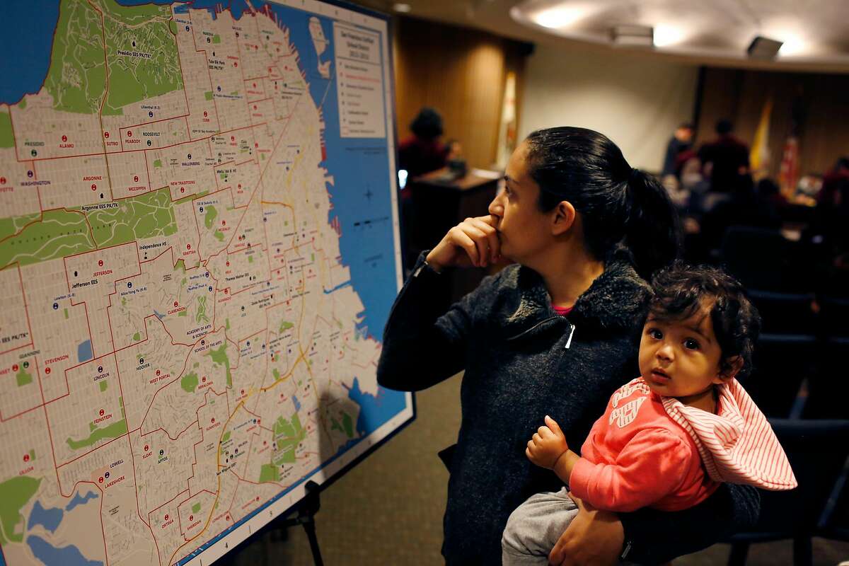 Rabia Mughal (l to r) holds her daughter Noor Mughal, 7 months, as she looks over a map of San Francisco Unified School District schools at the SFUSD office on the last day to hand in applications for round 1 for the upcoming school year on Friday, January 16, 2015 in San Francisco, Calif.