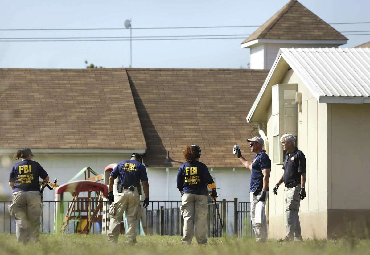 FBI agents use metal detectors as they investigate the area near the scene of the mass shooting at the First Baptist Church in Sutherland Springs, Texas, on Tuesday, Nov. 6, 2017.