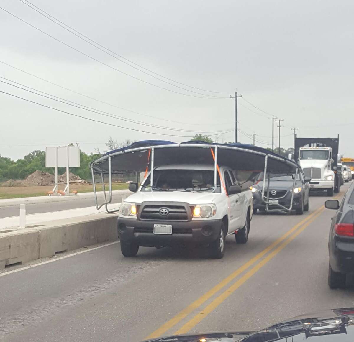 The odd sight of a trampoline strapped and hanging well over a Toyota pickup truck is making the rounds on the San Antonio subreddit. The photo shows the structure scraping the edges of the lane.