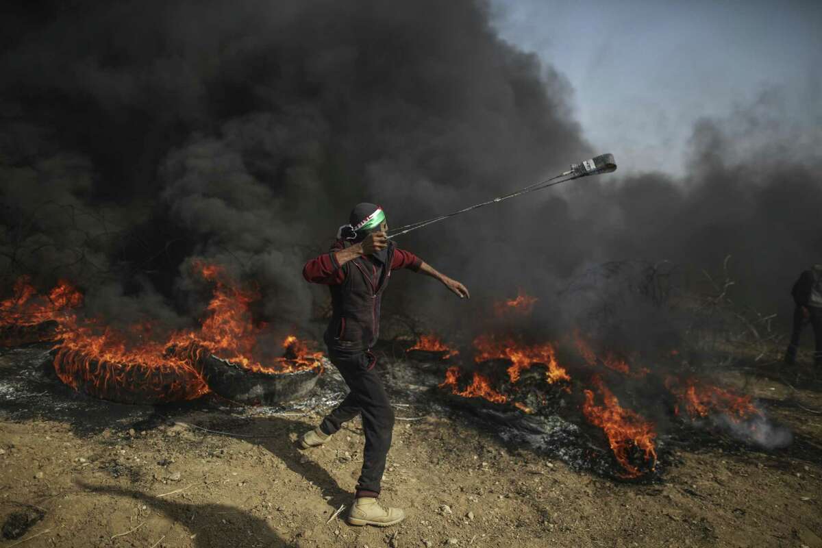 A protester slings rocks at Israeli troops during a protest on the Gaza Strip’s border with Israel on Friday.