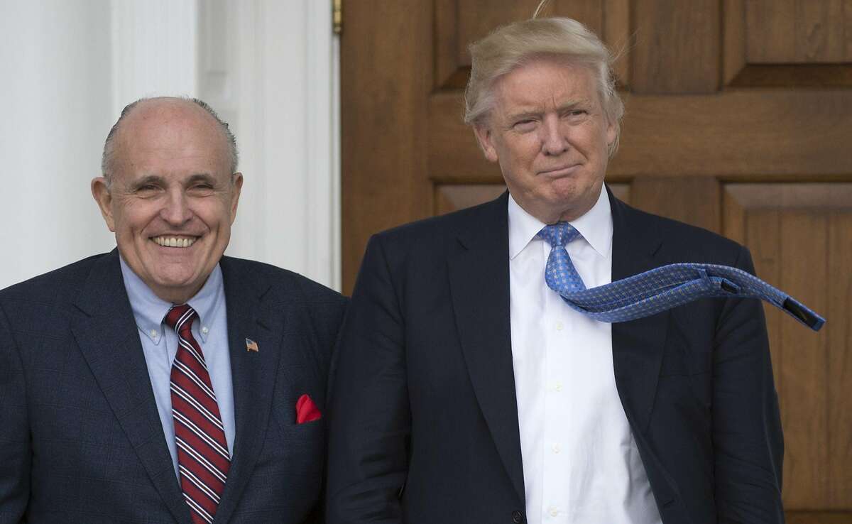 President-elect Donald Trump meets with former New York City Mayor Rudy Giuliani at the clubhouse of the Trump National Golf Club November 20, 2016 in Bedminster, New Jersey. Rudy Giuliani, US President Donald Trump's new lawyer, said Wednesday, May 2, 2018, on Fox News Channel's Hannity, that Trump repaid $130,000 to his personal attorney Michael Cohen for payment to porn star Stormy Daniels, contradicting the president's past comments on the controversy. / AFP PHOTO / Don EMMERTDON EMMERT/AFP/Getty Images