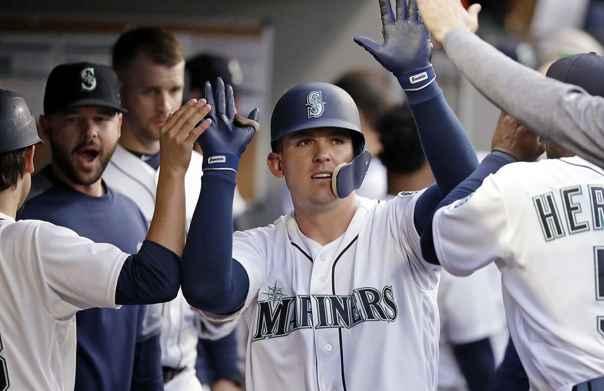 Seattle Mariners' Ryon Healy is congratulated on his home run against the Oakland Athletics during the third inning of a baseball game Wednesday, May 2, 2018, in Seattle. (AP Photo/Elaine Thompson)