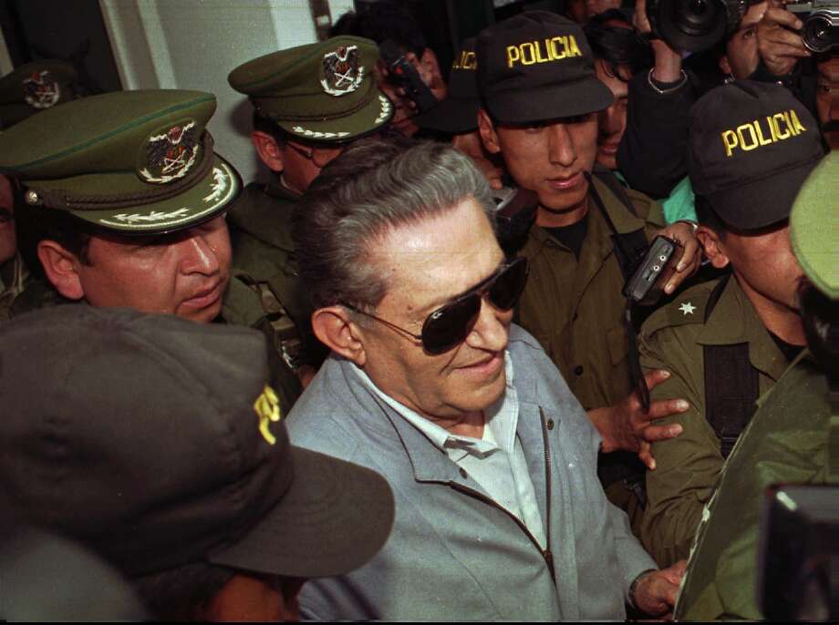 Bolivia’s jailed, ex-dictator Luis Garcia Meza is surrounded by police as he leaves a hospital in 1997. Photo: Sandra Boulanger / Associated Press 1997