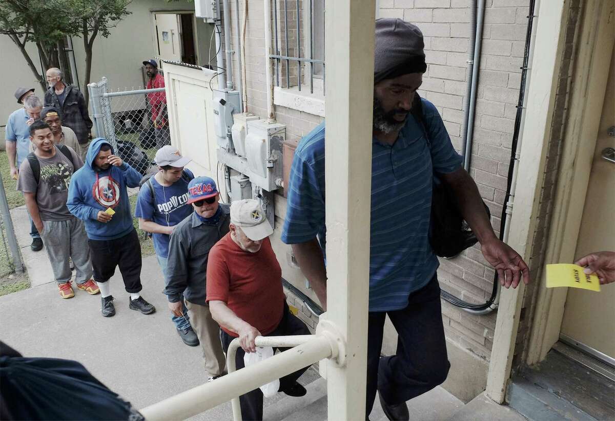 Some men get in line to receive tickets for a free sack lunch at Christian Assistance Ministries in downtown San Antonio on May 3, 2018.