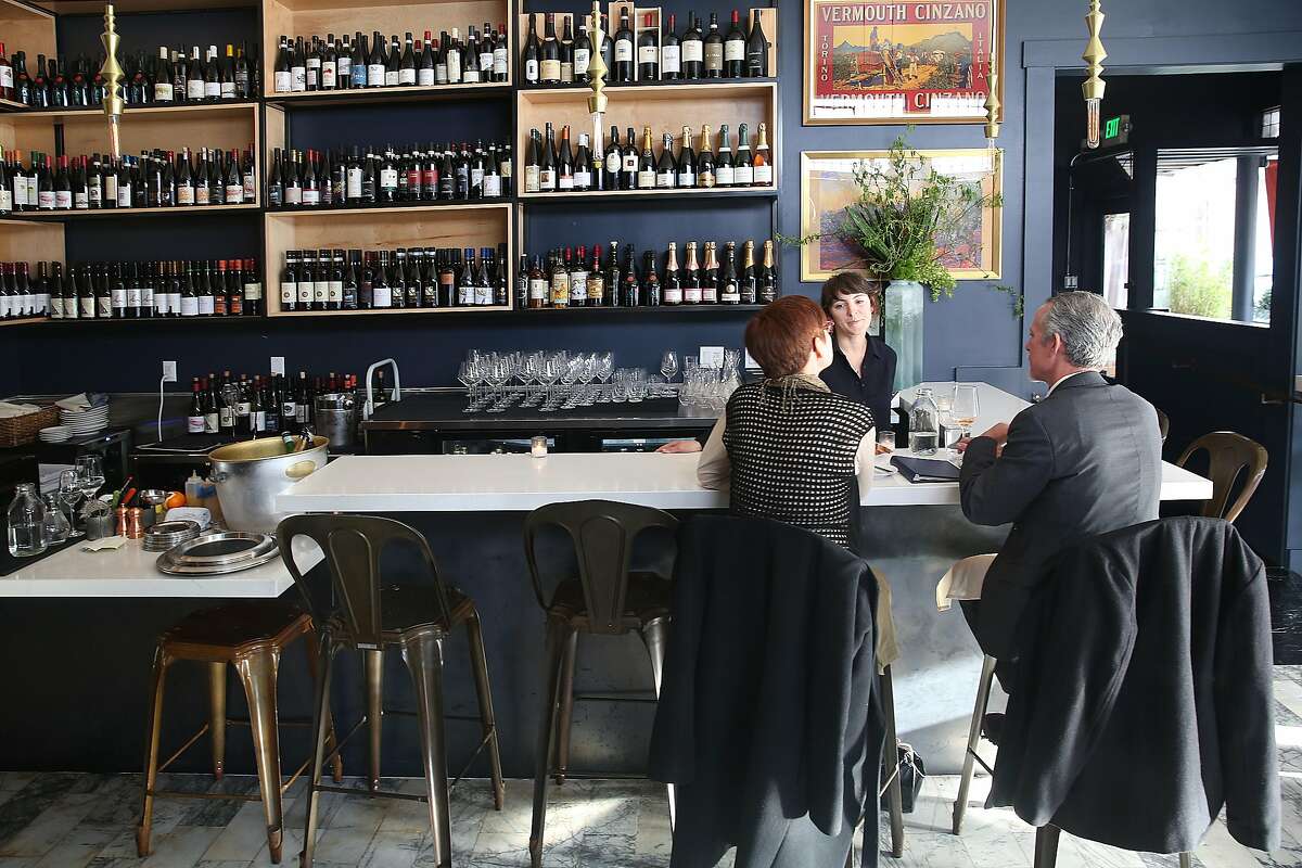 调酒师Stephanie罗马与丽莎埃尼斯在右手(左)和克里斯·埃尼斯(右)坐在酒吧庆祝他们22周年AltoVino是新的餐厅周五,4月27日,2018年,在旧金山,加州。