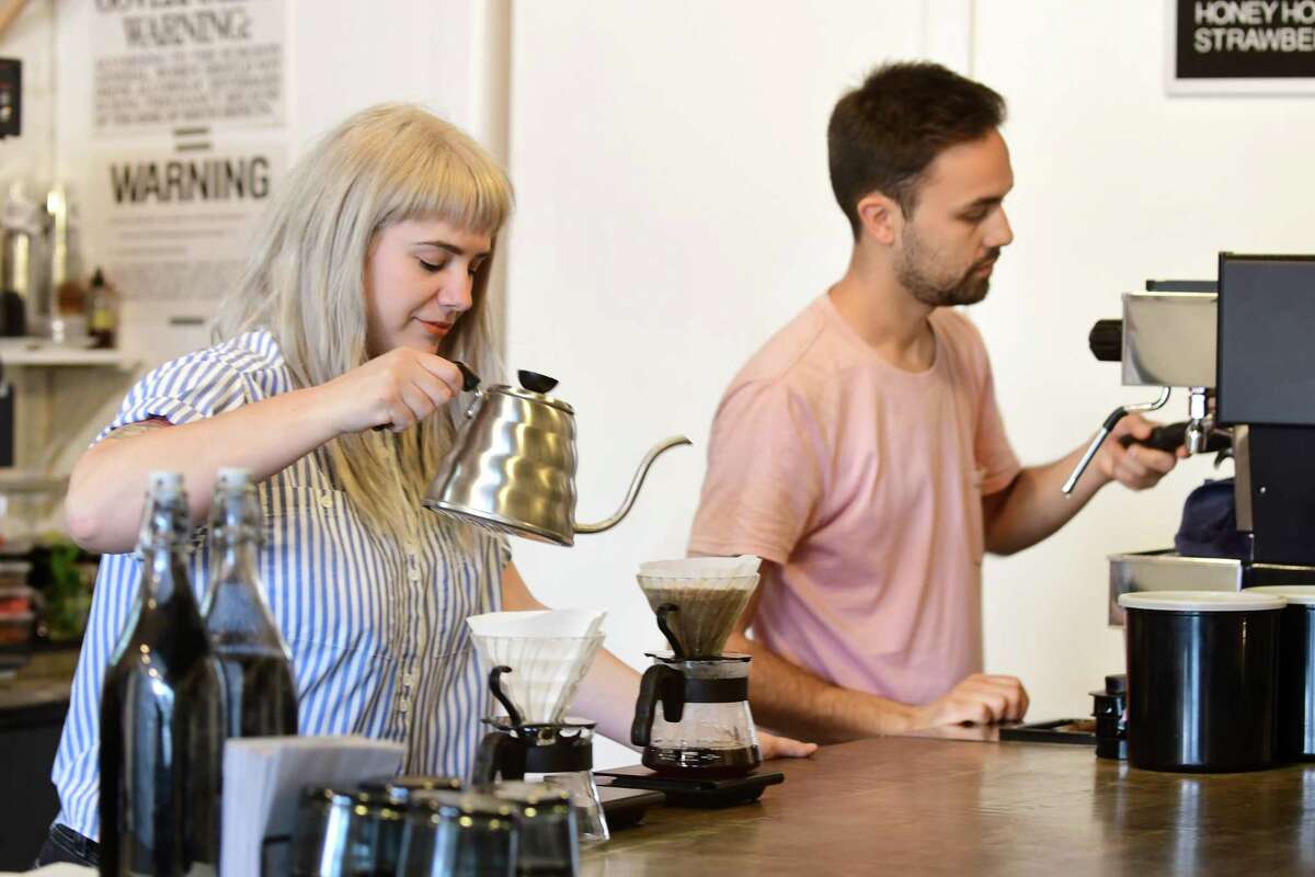 Felicity Jones, left, and Mike Romig make coffee at Superior Merchandise Co. in Troy in 2018. They are closing the cafe April 2 after eight years in business but will continue online sales of coffee, pantry staples and home goods as they focus on wholesale and subscription accounts for their Troy roastery, Touchy Coffee.