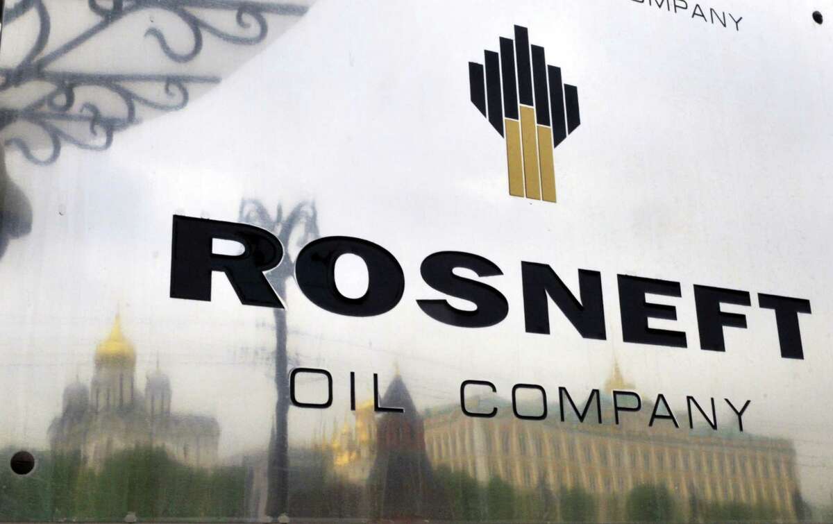 The Kremlin is reflected in the polished company plate of the state-controlled Russian oil giant Rosneft at the entrance of the headquarters in Moscow.