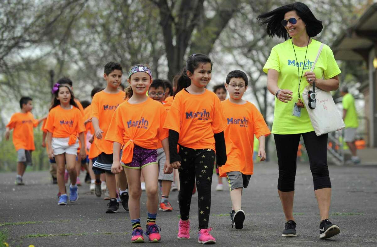 Marvin Elementary School teacher Michelle Suda leads her 2nd grade class in the school's walk-a-thon Friday, May 4, 2018, down Beach Road and around Shady Beach in Norwalk, Conn. The school had a fundraising goal of $10,000 and are just under $15,000 raised to date.