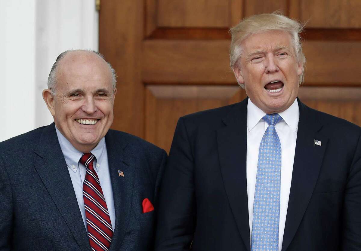 President Donald Trump calls out to media in 2016 as he and Giuliani pose for photographs as Giuliani arrives at the Trump National Golf Club Bedminster clubhouse in Bedminster, N.J..