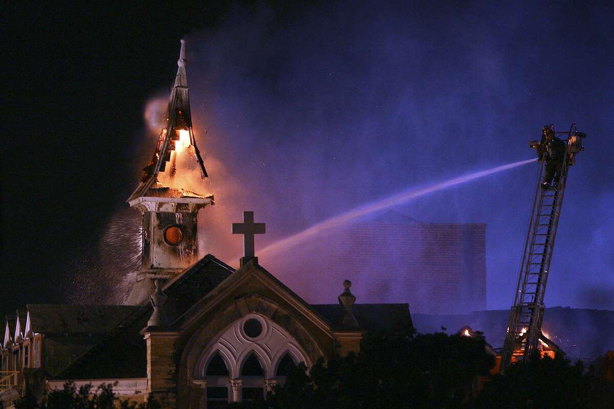 San Antonio firefighter spray water on the roof and a steeple of Our Lady of the Lake University which caught on fire Tuesday, May 6, 2008. AP Photo/San Antonio Express-News, Tom Reel) *** SAN ANTONIO OUT NO SALES MAGE OUT ***