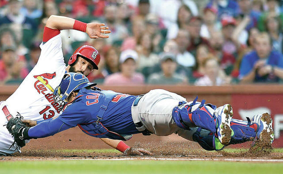 The Cardinals’ Matt Carpenter (13) eludes the tag from Cubs catcher Willson Contreras and slides safely into home in the first inning of Friday’s game at Busch Stadium.