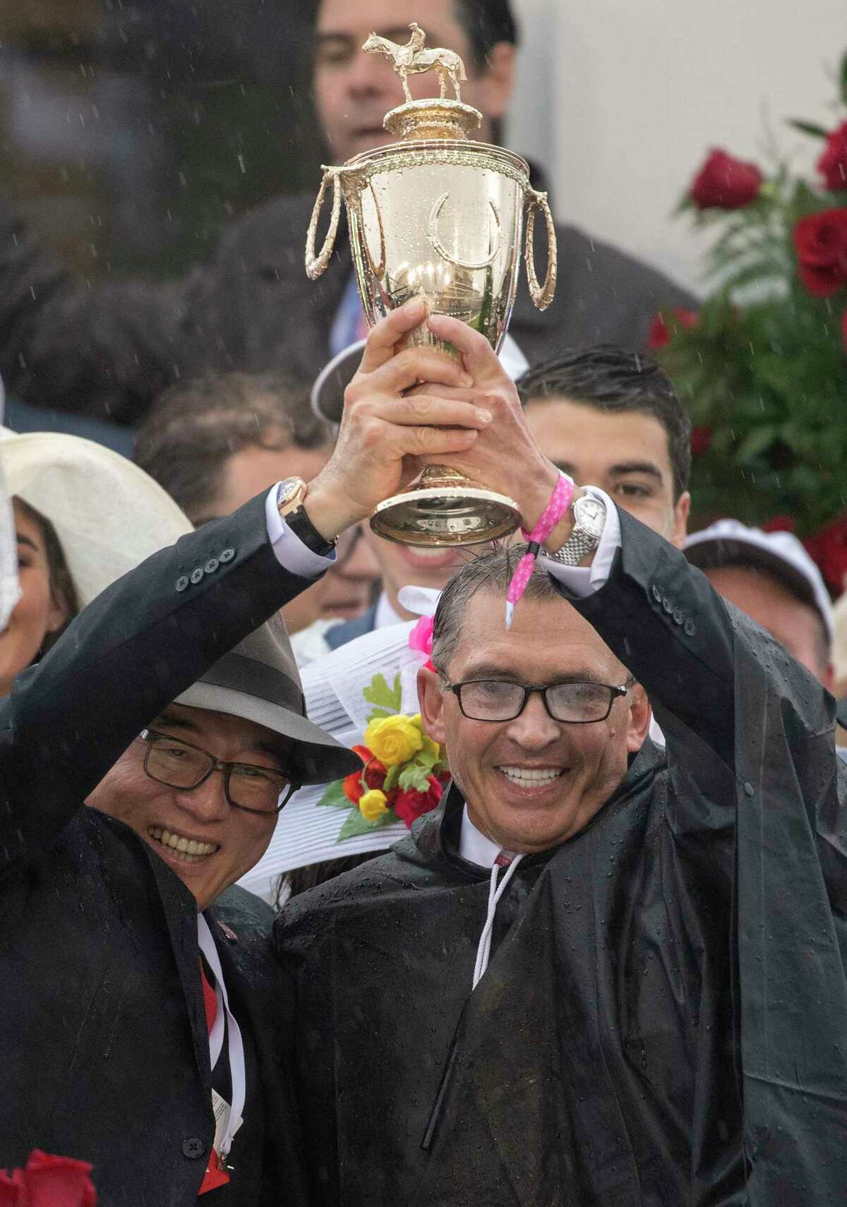 Owners Ah KhingTeo, left and Kenny Troutt hold up the Derby trophy in the winner's circle after their horse Justify won the 144th running of the Kentucky Derby at Churchill Downs Saturday May 5, 2018 in Louisville, Kentucky (Skip Dickstein/Times Union)